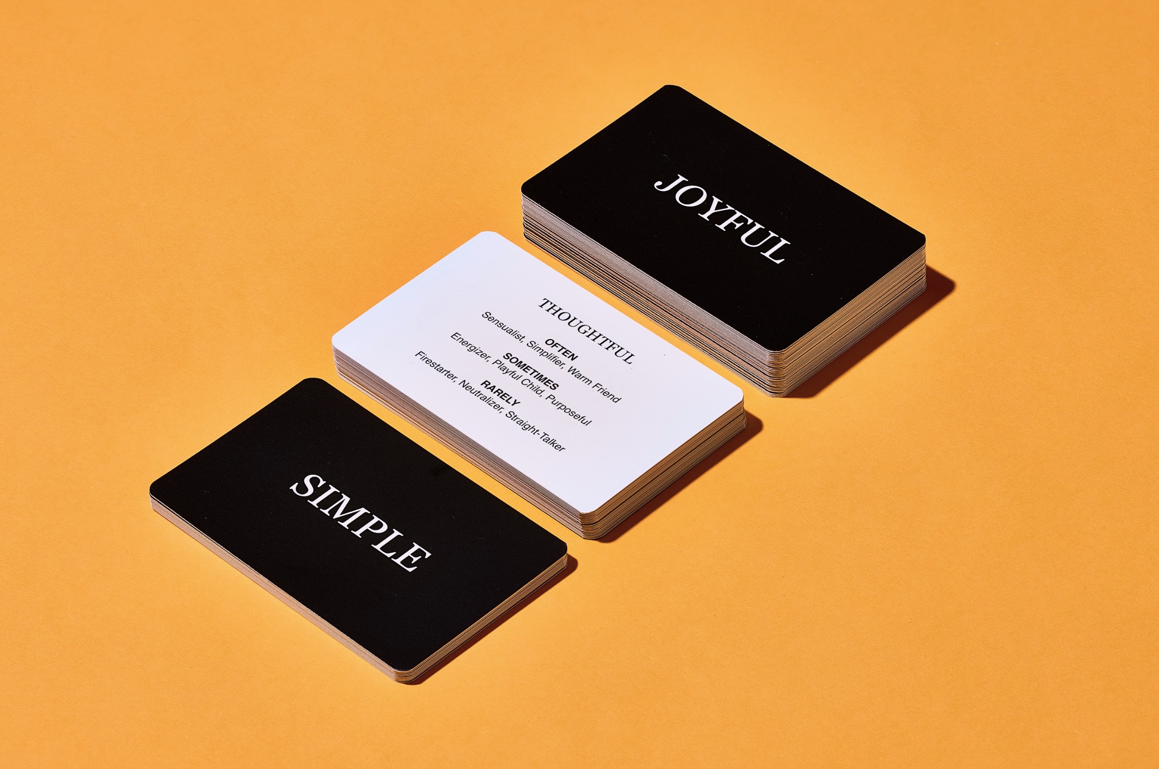 Voicebox tarot cards stacked in three neat piles on an orange background.